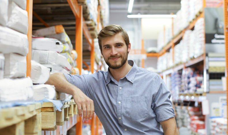 portrait of a smiling young warehouse worker working in a cash and carry wholesale store